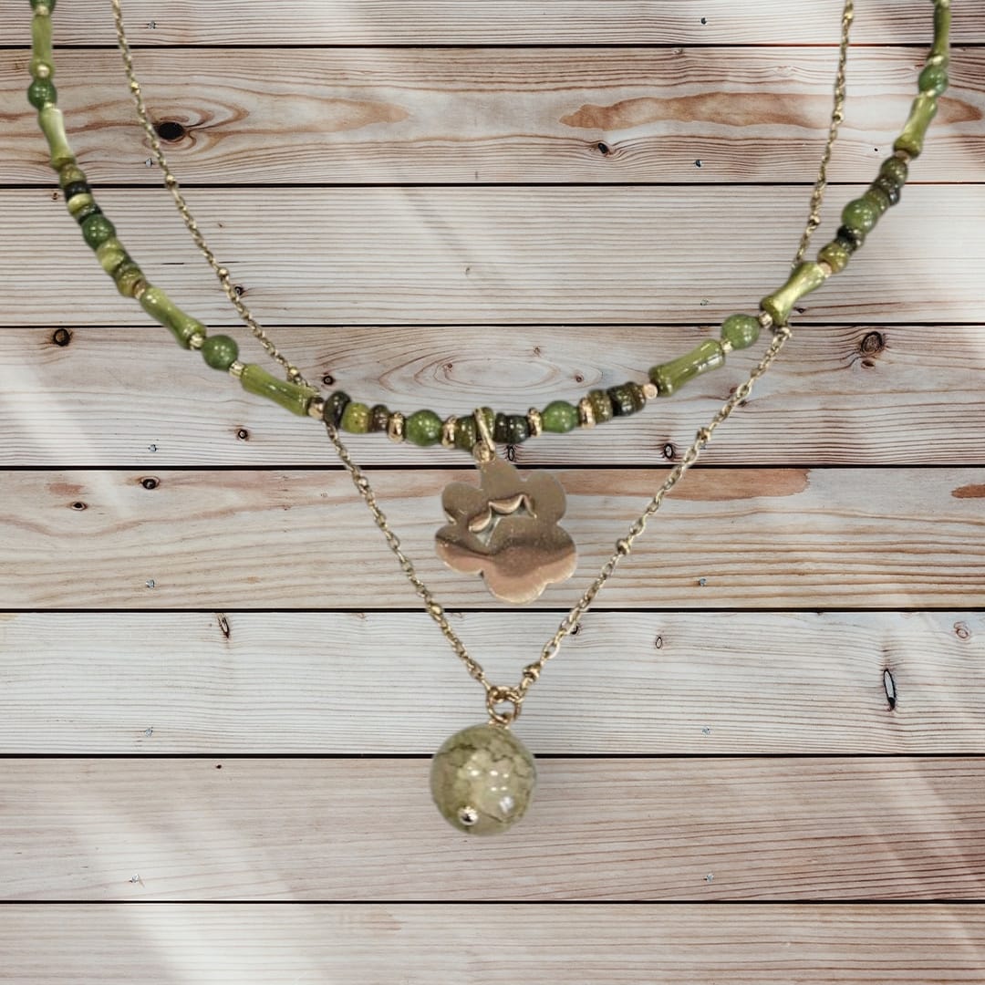 Collar de acero en color dorado con conchas y piedras verdes, con charm de huella