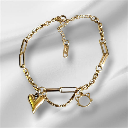 Pulsera de acero en color dorado con colgante de corazón y cara de gatete