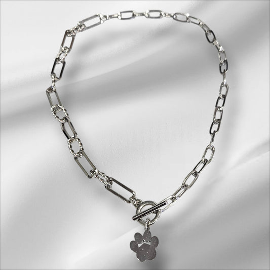 Collar de acero en color plateado con colgante de huella y cierre de broche