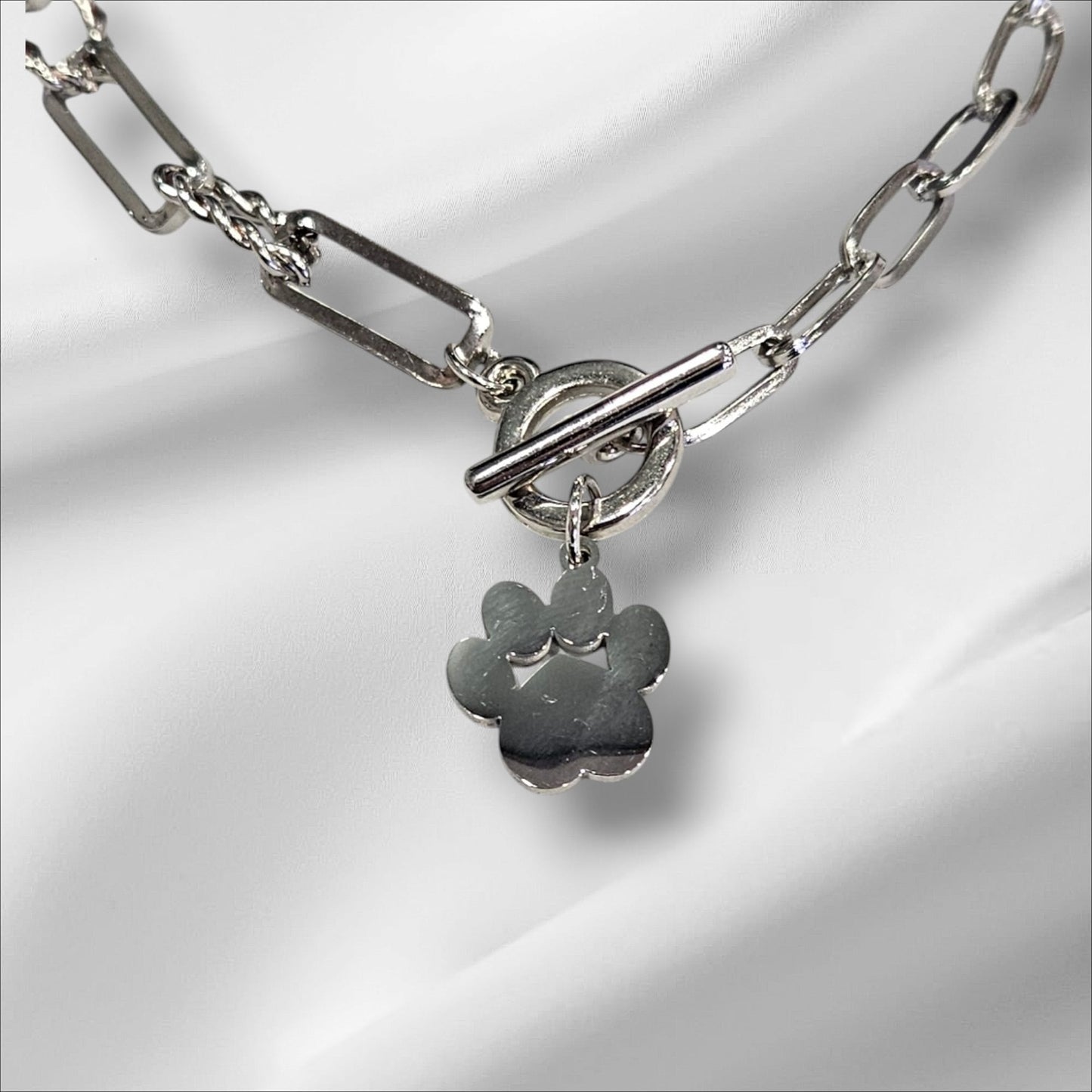 Collar de acero en color plateado con colgante de huella y cierre de broche