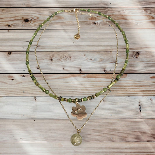 Collar de acero en color dorado con conchas y piedras verdes, con charm de huella