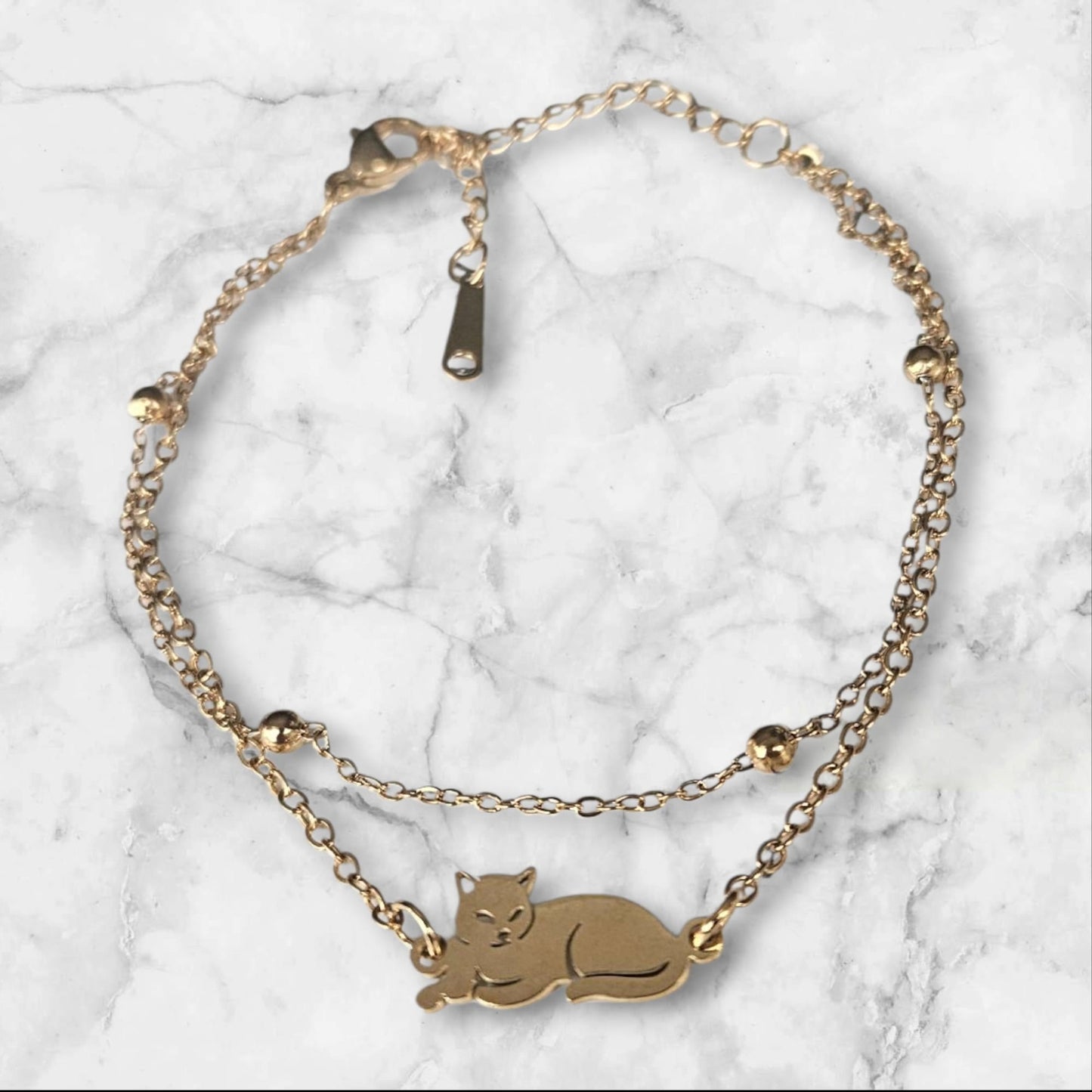 Pulsera de acero doble en color dorado con gato y bolitas