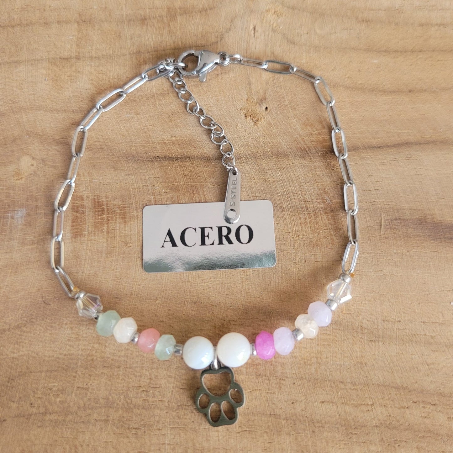 Pulsera de acero en color plata con cuentas de colores y colgante de huella
