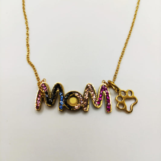 Collar de cadena de acero color dorado con colgante con letras con circonitas de colores "mamá" y huella de gatete