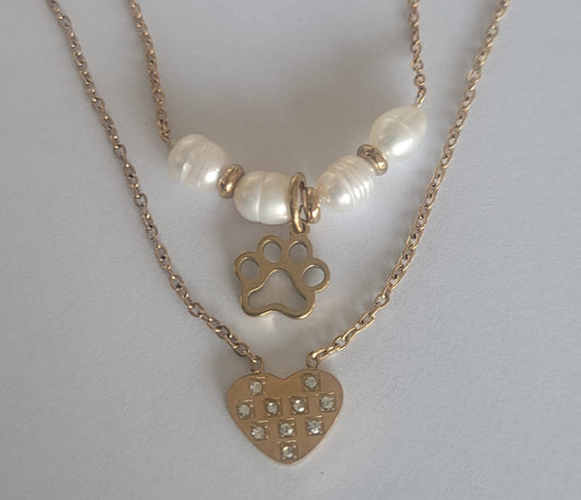 Cadena de acero en color dorado doble con huella, perlas y corazón.